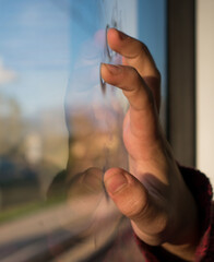 Mano en un cristal con reflejo.