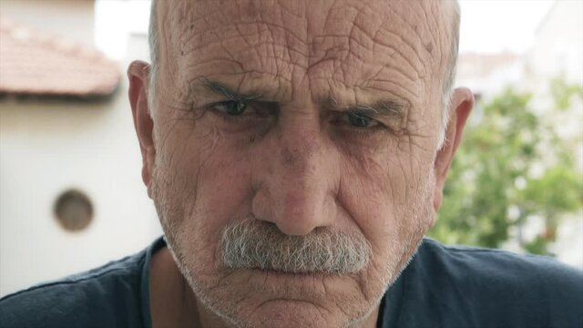 Angry old man portrait. Elderly man's close up face portrait