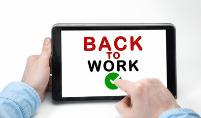 Male hands holding tablet pc with text BACK TO WORK on white background