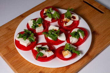 Antipasti. Tomatoes, mozzarella cheese, basil and balsamic vinegar on a white plate. The concept of vegetarian food.