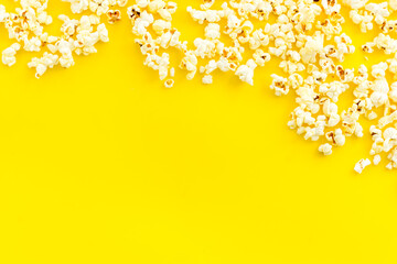 Popcorn on yellow table top-down frame copy space
