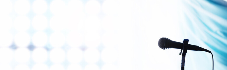 Stand with a microphone. Man holds hands a microphone on a tripod. Performance of the artist with a microphone. Scene with a microphone.