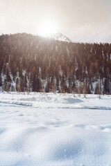 Snowy mountain scene with sun light over the mountains