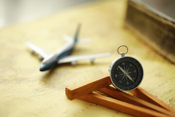 Travel and adventure search concept. Vintage aged map with a shabby book and compass. Shabby book and compass on the table.