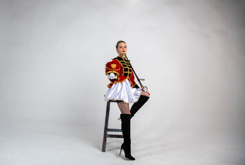 Fototapeta premium beautiful girl in a red antique hussar costume posing on a white background