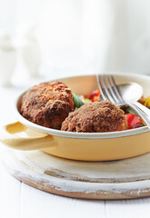 Fried Breaded Meatballs with Pappardelle Pasta, Vegetables and fresh Basil on bright wooden Background. Close up.