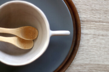 Set of artisan ceramic and cutlery in neutral colors. Top view.
