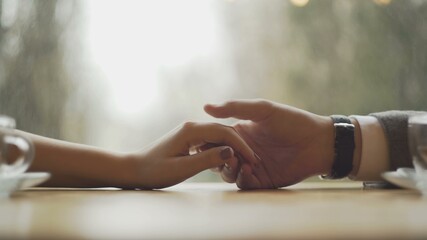 Young couple holding hands at the cafe