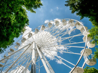 Amusement ride against blue sky. Close up with a white ferrys wheel.