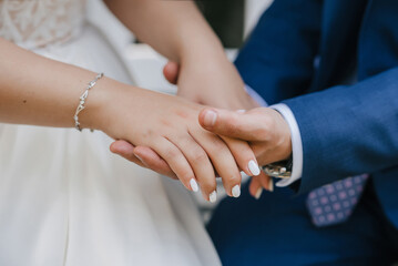 Obraz na płótnie Canvas groom gently holds the bride's hand at the wedding ceremony