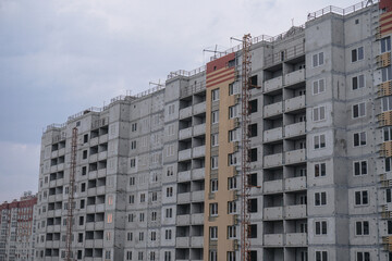Large construction site on a background of blue sky. Brick, panel apartment building. Industrial theme for design