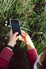 Woman holding a phone taking pictures of flowers