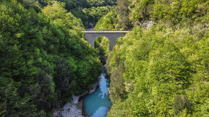 Fototapeta na wymiar Bridge Lavelle, Benevento, Italy The erosion of the water has created a real natural masterpiece surrounded by beautiful trees.