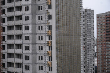 Obraz premium Large construction site on a background of blue sky. Brick, panel apartment building. Industrial theme for design
