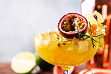 Passion fruit Alcoholic cocktail with gin, juice, rosemary and ice. Gray background, copper bar...