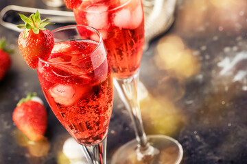 Rossini italian red alcoholic cocktail with sparkling wine, strawberry puree and ice in champagne...