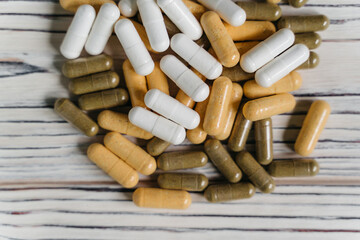  sprinkled pills and dietary supplements on a wooden background, vitamins and omega3 for immunity