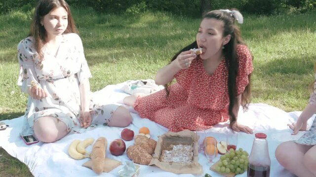 Group of friends spending time making a picnic. Female friendship. Female students relax and have rest, enjoy life.