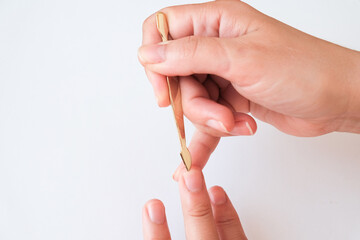 Manicure at home. Female hands use cuticle and dirt remover close up on a white background. View from above. Manicure at home