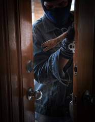 burglar holding Lock-picker to open a housedoor