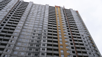 Large construction site on a background of blue sky. Brick, panel apartment building. Industrial theme for design