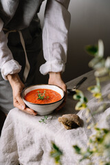 Female hands holding bowl with tomato soup. Traditional spanish gazpacho cold soup