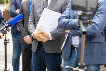 Lawyer or attorney holding documents, giving statement at news conference