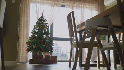 Christmas tree with decorative light and gift boxes on floor in luxury house
