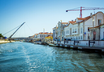 wide river that stretches in the city of Aveiro. houses over the river and clear blue water