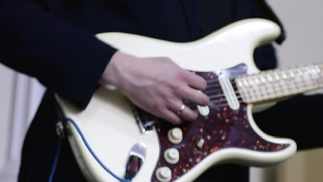 The guitarist is a member of the musical collective. Close-up of a guitar playing. dynamic scene