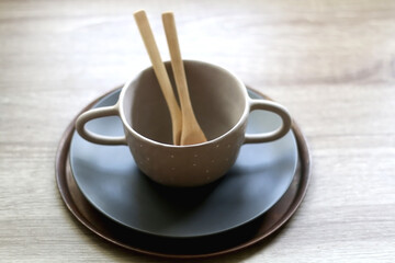 Set of artisan ceramic and cutlery in neutral colors. Selective focus.