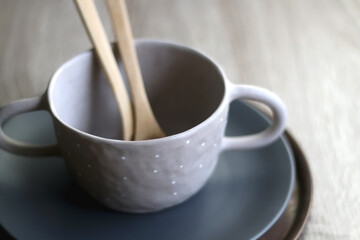 Set of artisan ceramic and cutlery in neutral colors. Selective focus.