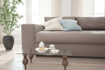 modern mock up with sofa,pillows,table,tea set and bred interior design. 3D illustration
