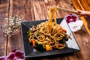 Eating beef and vegetables udon noodles wok