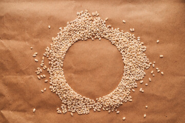 Oat croup in the shape of a circle lies on a cinnamon background