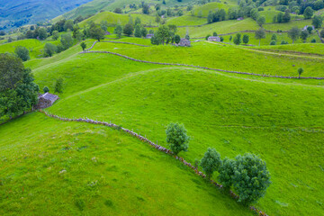 Obraz premium Aerial view with a drone of the spring landscape of pasiegas cabins and meadows in the Miera Valley in the Autonomous Community of Cantabria. Spain, Europe