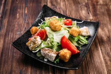 Caesar salad with fried tofu and deep-fried cheese