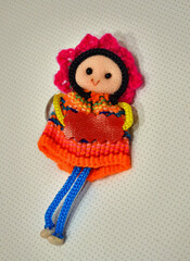 Popular Peruvian souvenir doll wearing multicolored woven clothing against white background, key...