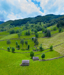 Aerial view with a drone of the spring landscape of pasiegas cabins and meadows in the Miera Valley in the Autonomous Community of Cantabria. Spain, Europe