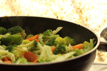 Half cooked vegetables on black fry pan