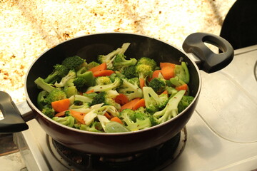 Half cooked vegetables on black fry pan