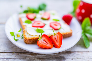 A delicious sandwich with mascarpone and fresh strawberries. Healthy breakfast.