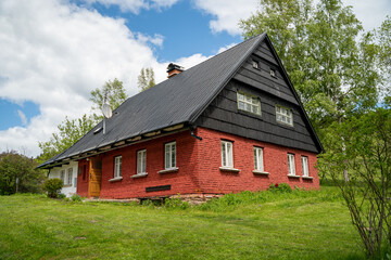 Fototapeta na wymiar Red mountain cottage with black roof