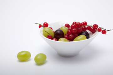 White bowl with grapes and redcurrents.