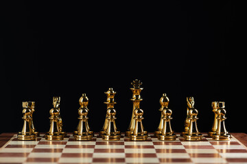 Golden chess figures standing on chessboard