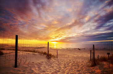 Scenic sunset over Baltic Sea beach with dramatic cloudscape, Poland.