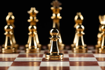 Golden chess figures standing on chessboard
