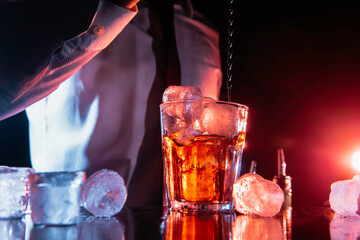 Expert bartender is making cocktail at night club. Barman preparing cocktails at the bar counter.