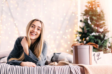 girl lies on the bed and looks into the camera. present on the b