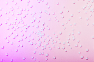 White balls on neon pink background. Trending background for beauty themes.